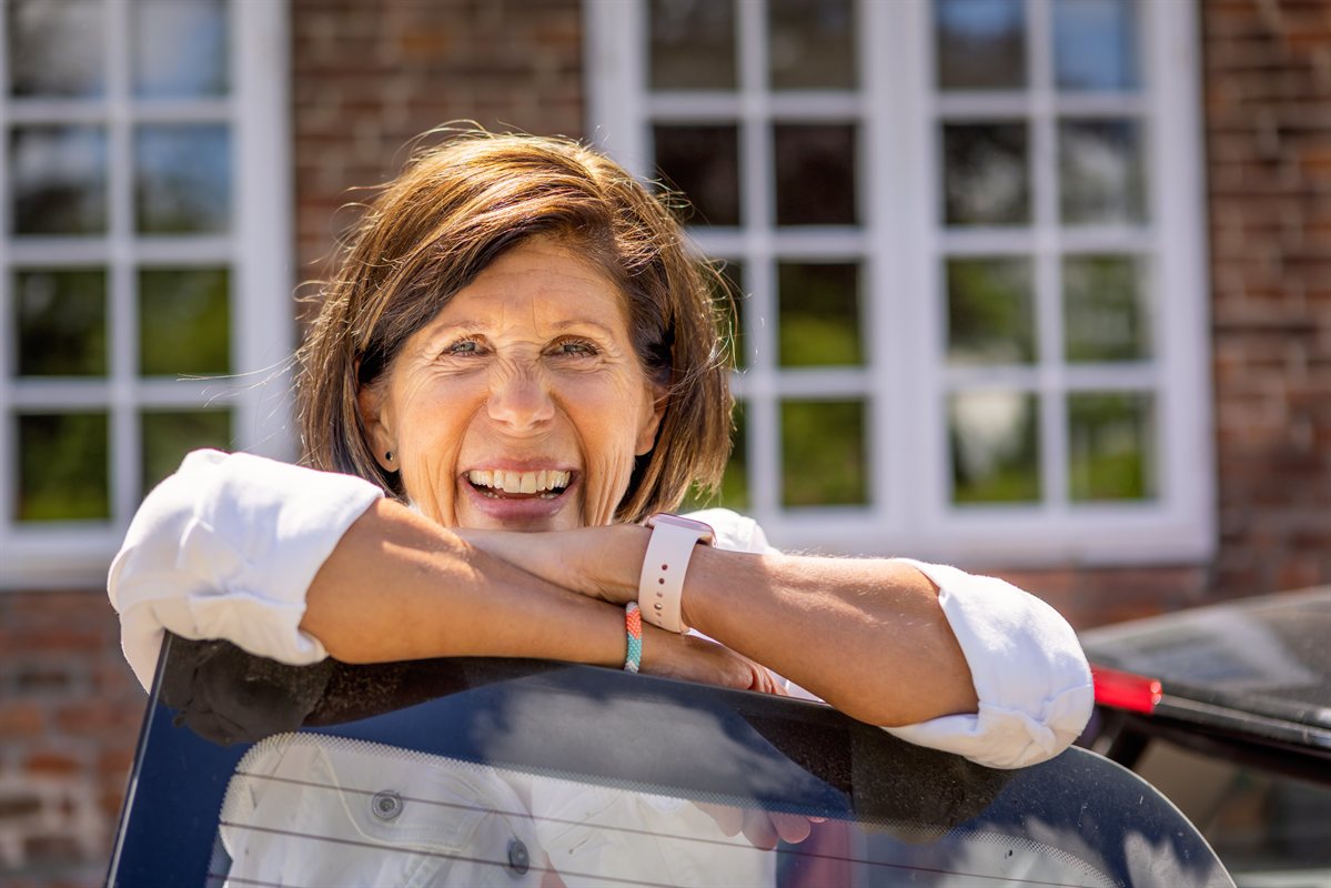 Dr. Claudia Editha Richter, lachend am Haus in Nordfriesland